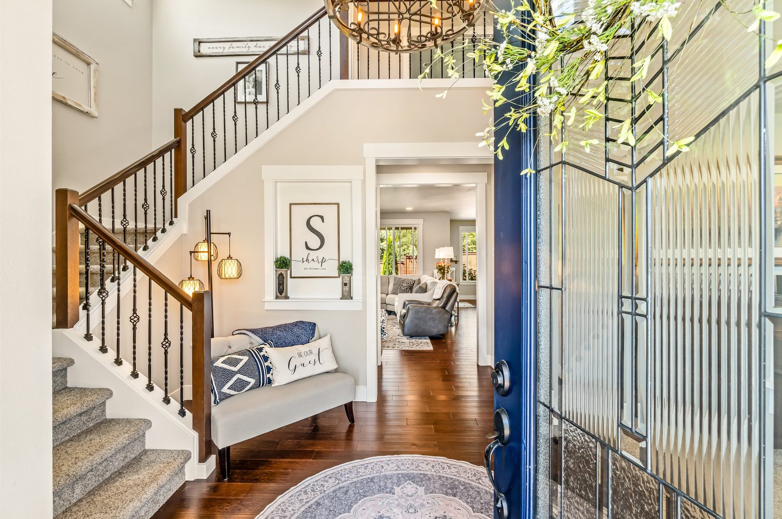 Foyer with grand staircase and modern entry door in a Seattle-area home
